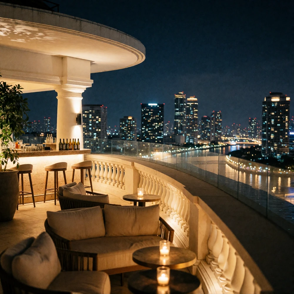 Open rooftop lounge terrace above Bangkok at night with a glittering skyline and dark river bend