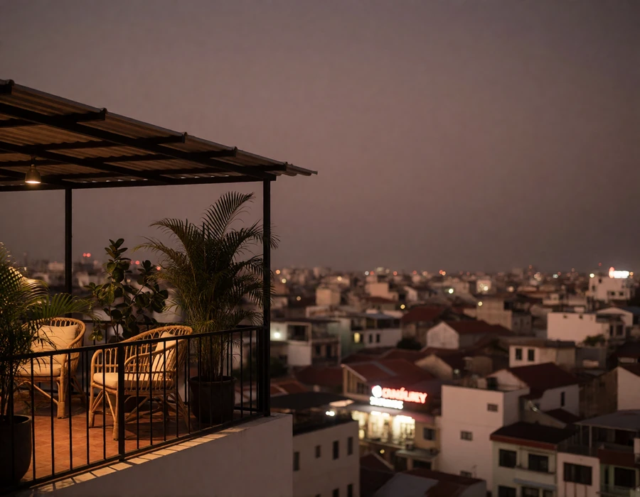 Rooftop terrace with rattan seating overlooking a glowing Vietnamese cityscape at twilight